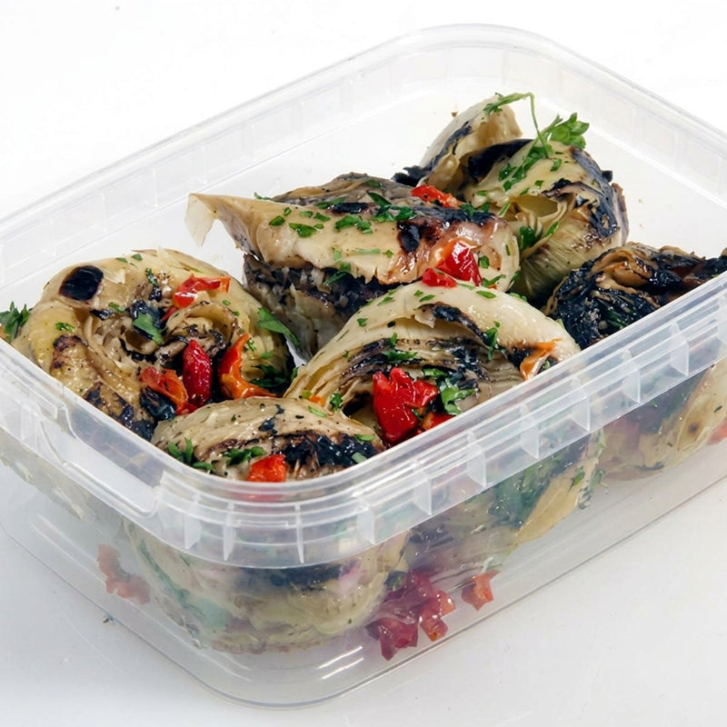 Gegrillte kleine Artischockenherzen in der Verpackung, mit Petersilie und Paprika garniert
